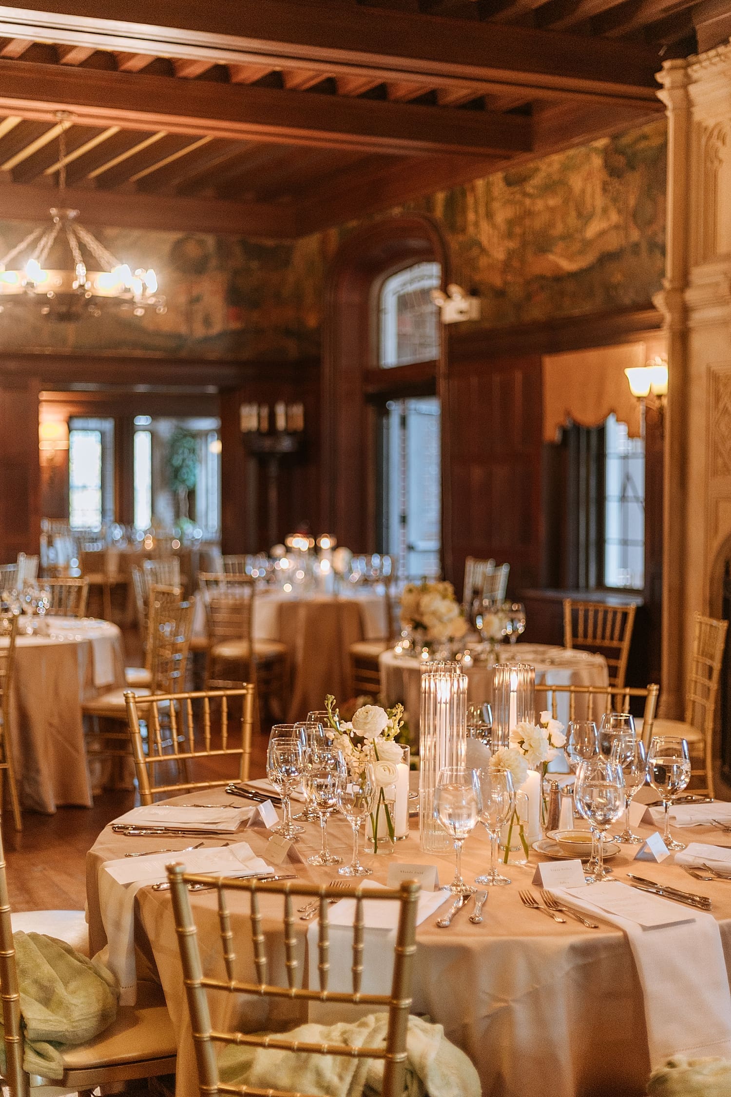 circle reception tables set up with clear glass and candles at Waveny House