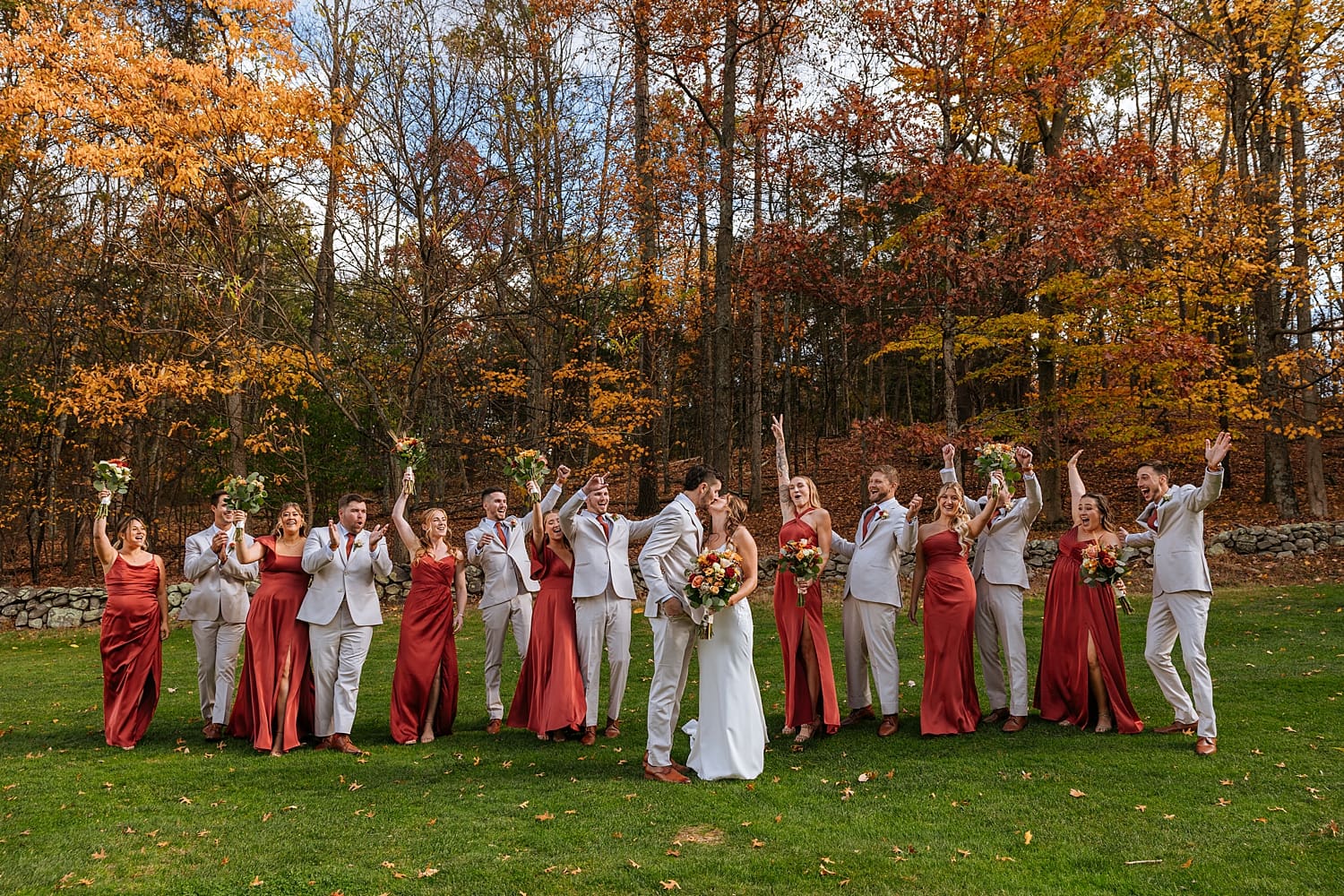 wedding party throws hands up in celebration outside by Kelly Jean Photography