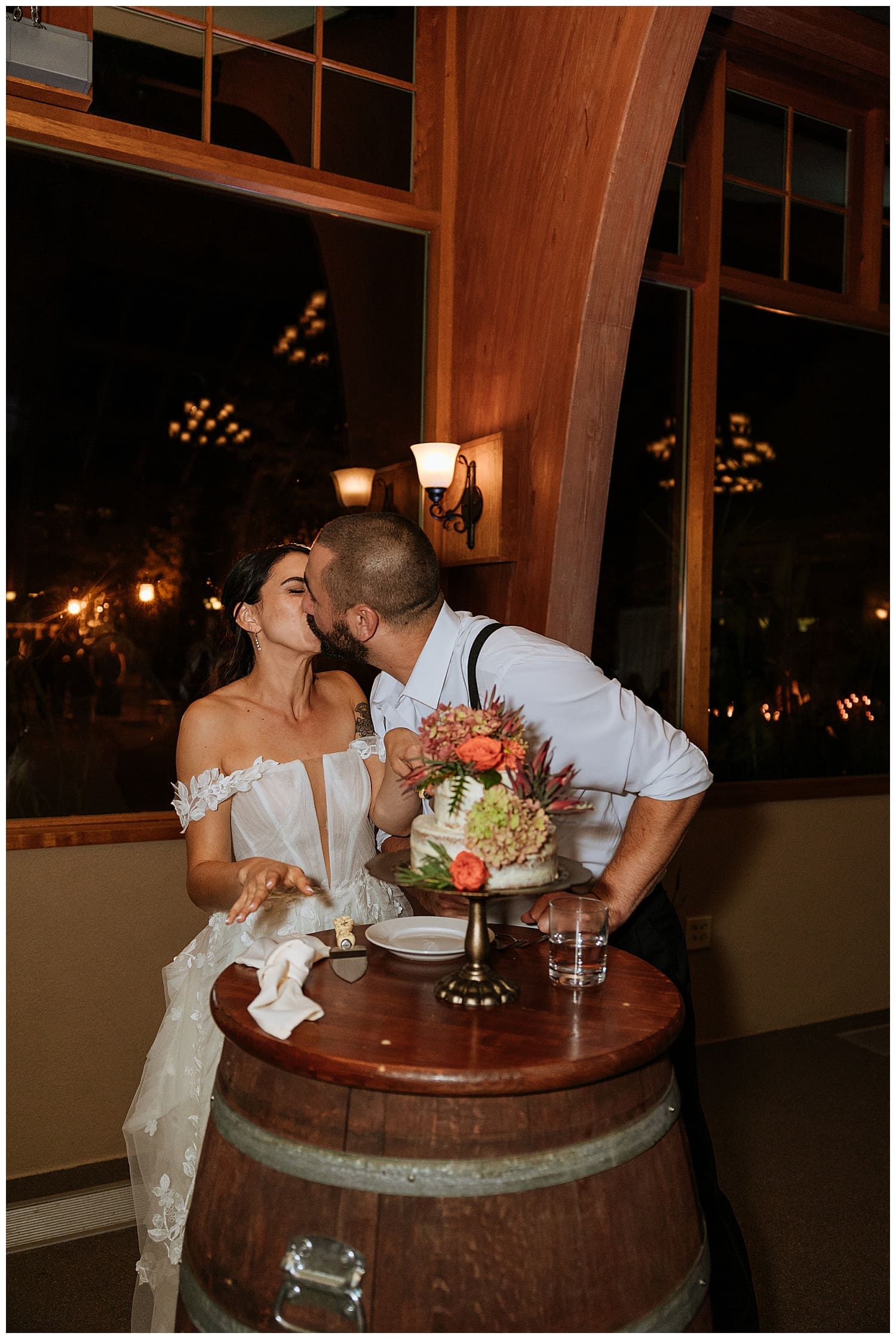 man leans in to kiss his new wife after cutting cake by Kelly Jean Photography